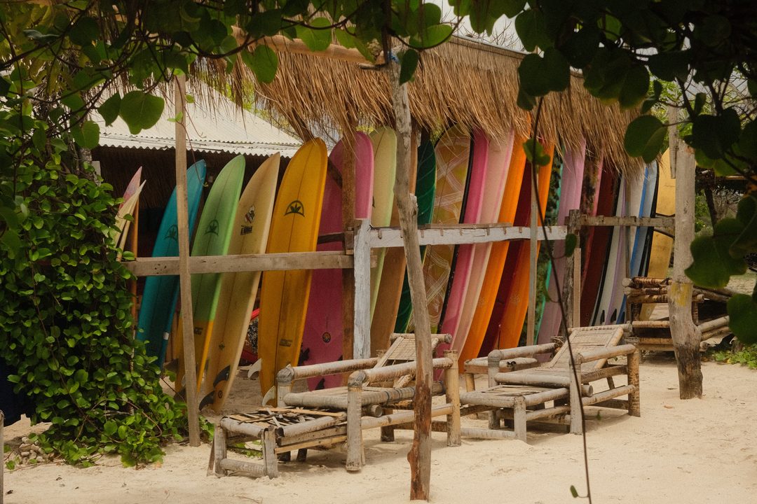 Surfboards under a thatched roof on the beach